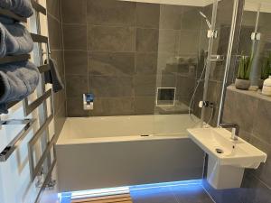 a bathroom with a bath tub and a sink at Stunning Luxury 3 Bed Penthouse Sleeps 2 to 6 in Hythe +58 photos