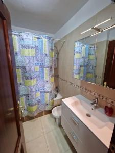 a bathroom with a sink and a toilet and a shower curtain at Balcon del Atlantico in San Miguel de Abona