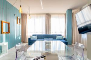 トリノにあるTorino Loftのリビングルーム(青いソファ、ガラスのテーブル付)