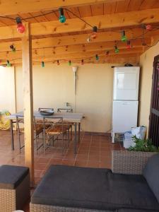 a patio with a table and a refrigerator and a table at Balcon del Atlantico in San Miguel de Abona