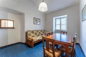 a dining room with a table and a couch at Orbetello Giannella Apartment in Giannella