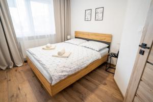 a bedroom with a bed with two towels on it at Apartmany ROSTER in Liptovský Mikuláš