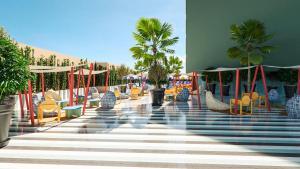 a pool with chairs and palm trees in a resort at tent Mojito Suites in Magaluf
