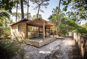 a tiny house in the woods with a deck at Huttopia Arcachon in Arcachon