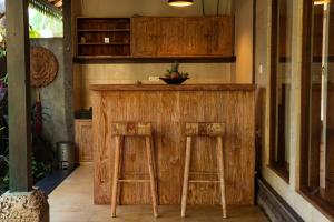 a wooden bar with two stools in a room at Cozy Jungle View 1-Bedroom Villa with Private Pool in Ubud