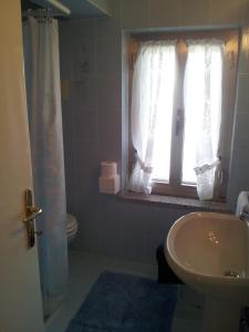 a bathroom with a sink and a toilet and a window at Meublè Al Ponte in Grado