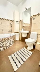 ein Badezimmer mit einem WC, einem Waschbecken und einer Badewanne in der Unterkunft Apartament na Brudzewskiego in Przemyśl