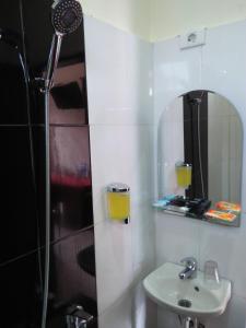 a bathroom with a shower and a sink and a mirror at Zoé’s Paradise Waterfront Hotel in Tuk Tuk