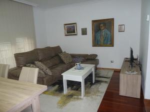 ein Wohnzimmer mit einem Sofa und einem Tisch in der Unterkunft Las Palmeras in Caldas de Reis