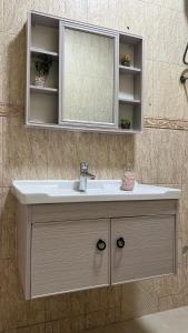 a bathroom vanity with a sink and a mirror at ضيافة الأمير The Prince Hospitality in Barka