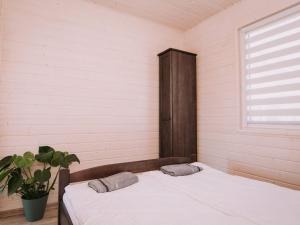 a bed with two pillows in a room with a window at Family holiday resort holiday houses Bobolin in Bobolin
