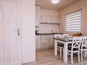 a kitchen with a table and chairs in a room at Family holiday resort holiday houses Bobolin in Bobolin