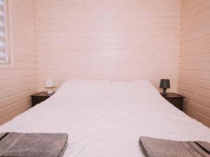 a large white bed in a room with two lamps at Family holiday resort holiday houses Bobolin in Bobolin