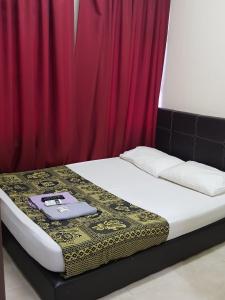 a bed in front of a red curtain at Meera Heritage Motel in George Town