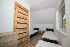 a small room with two beds and a window at Comfortable two story holiday houses Jaros awiec in Jarosławiec