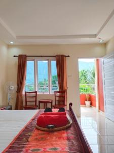 um quarto com uma cama com uma almofada vermelha em Zoé’s Paradise Waterfront Hotel em Tuktuk Siadong