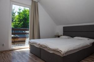 a bedroom with a large bed and a large window at Comfortable two story holiday houses Jaros awiec in Jarosławiec