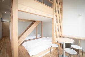 Zimmer mit 2 Etagenbetten, einem Tisch und Stühlen in der Unterkunft Teshima ESPOIR PARK in Ieura