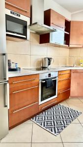 a kitchen with wooden cabinets and a stove at Apartament Elegant 1 in Przemyśl