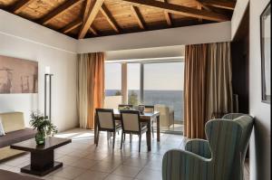 sala de estar con mesa y sillas y comedor en Apostolata Island Resort and Spa, en Skala