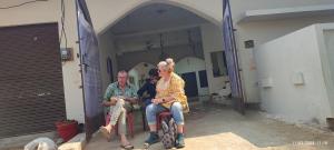 eine Gruppe von Personen, die in einem Gebäude auf Stühlen sitzen in der Unterkunft Khajurāho Hostel in Khajurāho