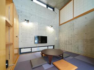 Premier Kinshicho-プレミア錦糸町- في طوكيو: غرفة مع طاولة وتلفزيون على الحائط