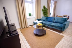 un soggiorno con divano blu e tavolo di Apartmán RADKA a Zvolen