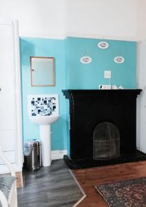 a bathroom with blue walls and a fireplace at Ben Your Friend Youth Foundation in Cape Town