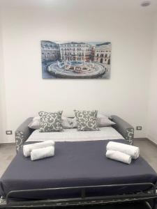 uma cama com almofadas num quarto em La casetta di salvuccio em Palermo