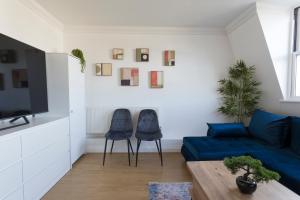 倫敦的住宿－Cosy 2-Bed Flat - Great Views of London!，客厅配有2把蓝色椅子和1张沙发