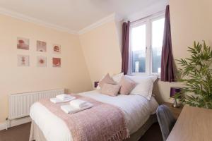 倫敦的住宿－Cosy 2-Bed Flat - Great Views of London!，一间卧室配有一张床,上面有两条毛巾