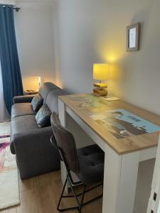 ein Wohnzimmer mit einem Schreibtisch und einem Sofa in der Unterkunft Chambre Privée chez L' Habitant in Trignac