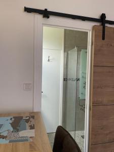 porta a vetri che conduce a un bagno con doccia di Chambre Privée chez L' Habitant a Trignac