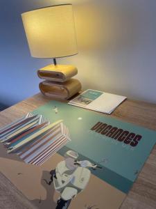 a table with a magazine and a lamp on top of it at Chambre Privée chez L' Habitant in Trignac