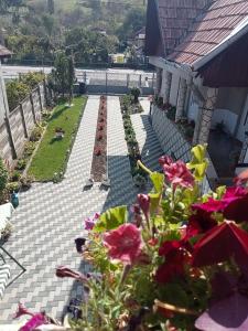 een patio met uitzicht op een tuin met bloemen bij Casa Aura.!! in Ocna-Mureşului