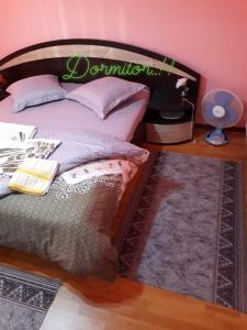 een slaapkamer met een bed met een houten hoofdeinde bij Casa Aura.!! in Ocna-Mureşului