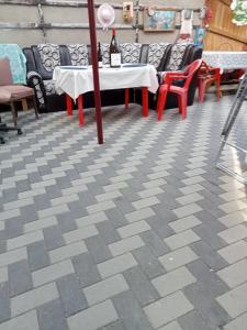 een patio met tafels en stoelen en een tafel met een fles wijn bij Casa Aura.!! in Ocna-Mureşului