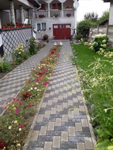 een stenen loopbrug voor een huis met bloemen bij Casa Aura.!! in Ocna-Mureşului
