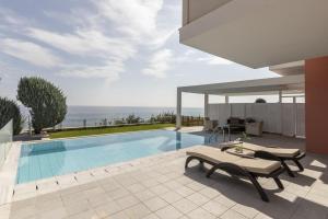 a house with a swimming pool and a patio at Apostolata Island Resort and Spa in Skala