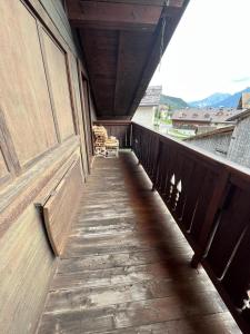 einen Holzbalkon mit Blick auf ein Gebäude in der Unterkunft Mansarda di pregio in San Vito di Cadore