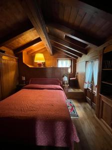 a bedroom with a bed with a red blanket at Mansarda di pregio in San Vito di Cadore