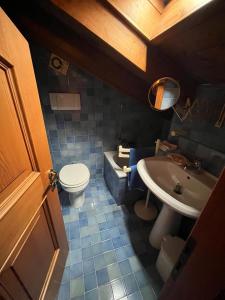 a bathroom with a toilet and a sink and a tub at Mansarda di pregio in San Vito di Cadore