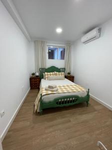ein Schlafzimmer mit einem grünen Bett in einem Zimmer in der Unterkunft Casa Luna de Antequera in Antequera