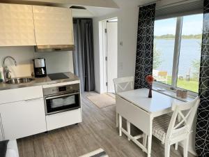uma cozinha com uma mesa e uma sala de jantar com vista em Cozy cottage located on a nice sea plot on Boholmarna outside Kalmar em Kalmar