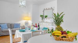 a living room with a table with a basket of fruit at CASA MAESTRALE 6, Emma Villas in Palau