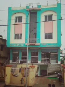 um edifício azul e branco com pessoas à frente dele em Hotel President inn,Raxaul em Raxaul