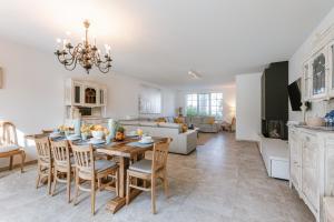une salle à manger et un salon avec une table et des chaises dans l'établissement Villa Josephine, à Coxyde