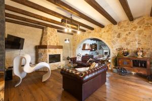 ein Wohnzimmer mit einem Sofa und einer Steinmauer in der Unterkunft VILLA I MORI 4, Emma Villas in Rosolini