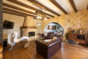 a living room with a couch and a stone wall at VILLA I MORI 4, Emma Villas in Rosolini