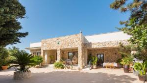 a large stone building with a table and chairs at VILLA I MORI 4, Emma Villas in Rosolini